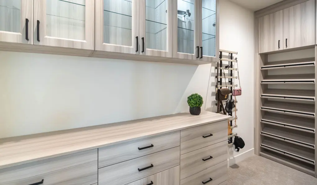 light gray beige wooden closet system with hanging purses 