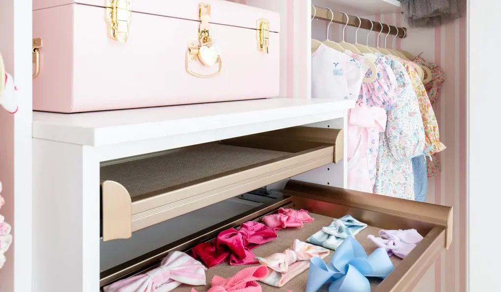 Custom child closet with pink accents and pull out drawers