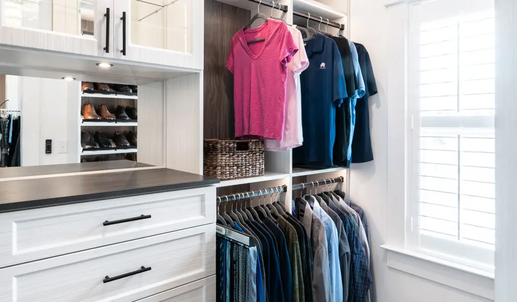 Custom closet with white shelves and dark brown accent and black hardware