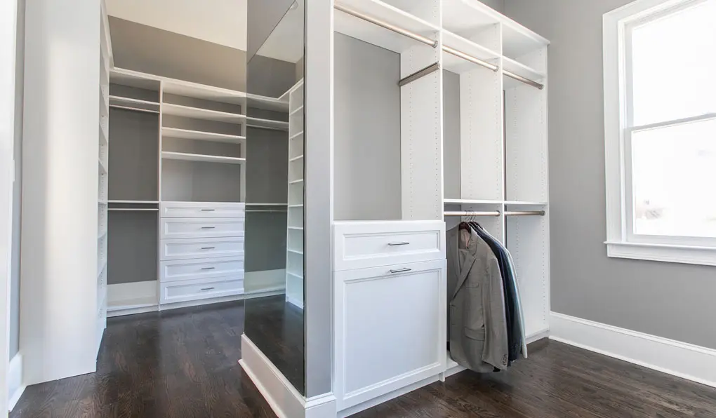 Empty white closet with gray wall and wooden floors 