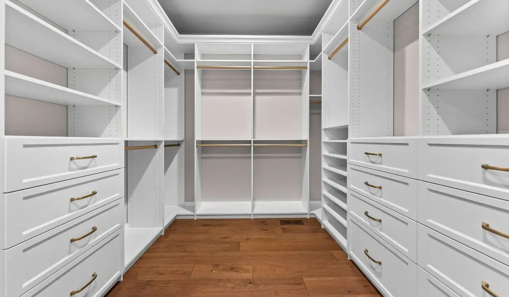 Empty white custom closet with gold hardware